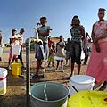 ACTION Panorama - People in the township of Thembisa South Africa stand in line waiting to fill a bucket with water - the irony is that the photographer had left a hotel with dancing water fountains less than 15minutes drive away.